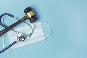 Legal gavel with stethoscope and medical mask, symbolizing personal injury claims during COVID-19.